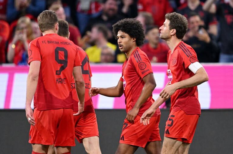 سيرج جنابري لاعب بايرن ميونيخ يحتفل مع زملائه بتسجيله هدف فريقه الثاني أمام بروسيا دورتموند في مباراتهما بدوري الدرجة الأولى الألماني لكرة القدم في ميونيخ يوم 12 أبريل نيسان 2025