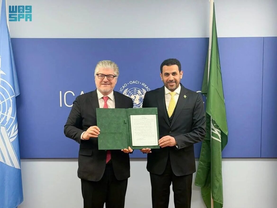 Two men in business suits pose with an open green folder containing a certificate in front of a blue ICAO backdrop and flags on either side.