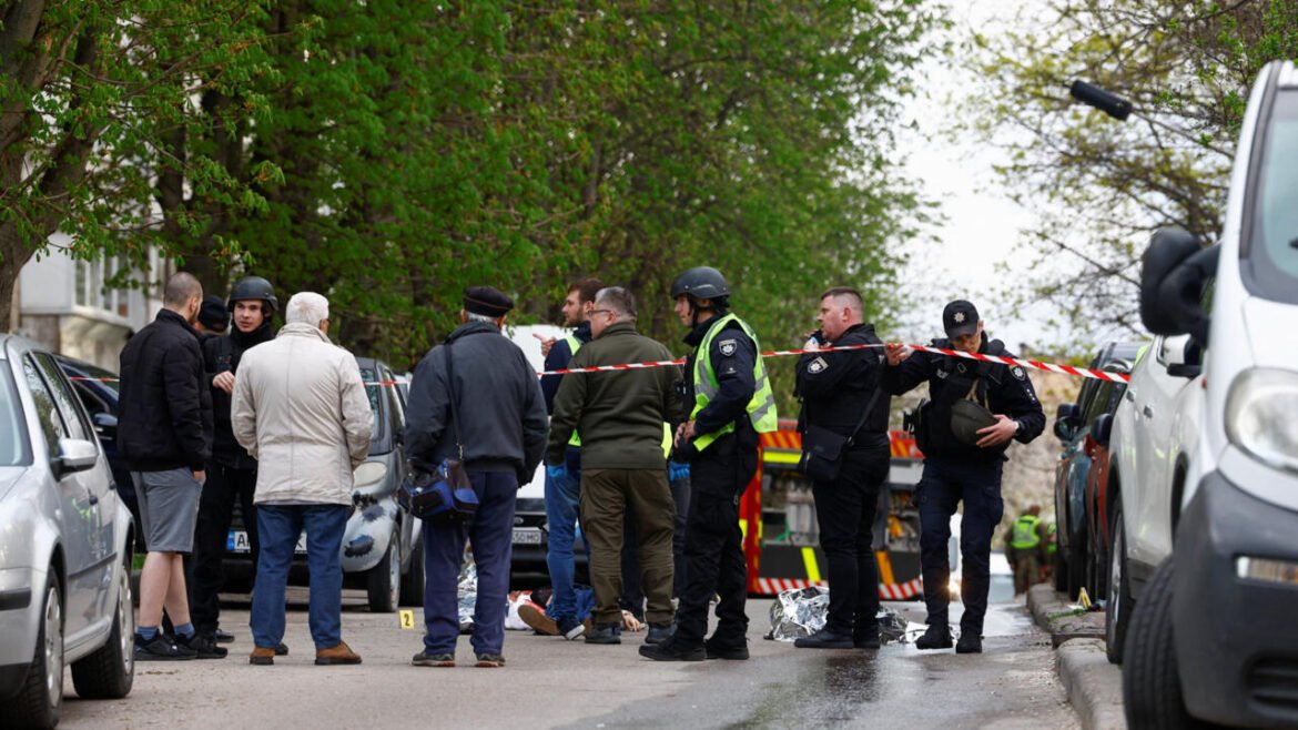 Police officers and investigators secure a cordoned street crime scene with red-and-white tape, cars parked nearby, and bystanders observing.