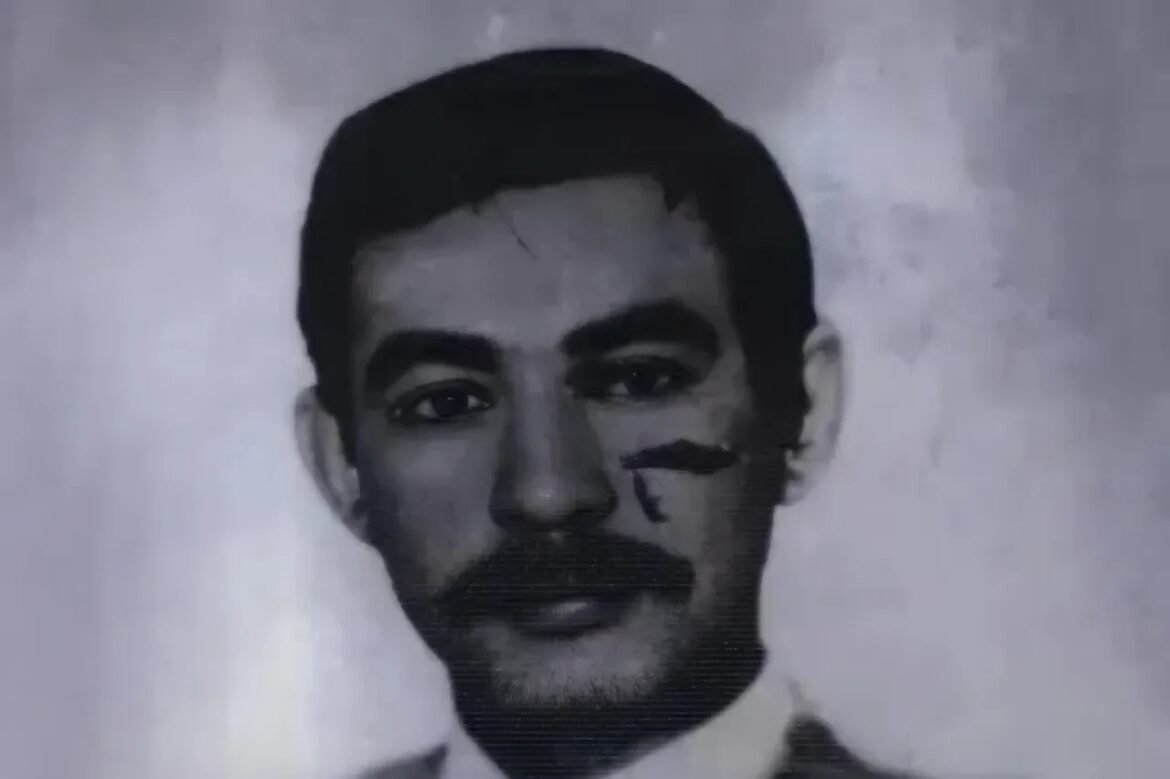 Black-and-white portrait of a man with short dark hair and a mustache, facing the camera.