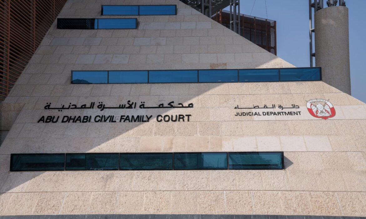 Abu Dhabi Civil Family Court building facade with blue glass windows and the sign 'Abu Dhabi Civil Family Court' beside the Judicial Department emblem in Arabic and English