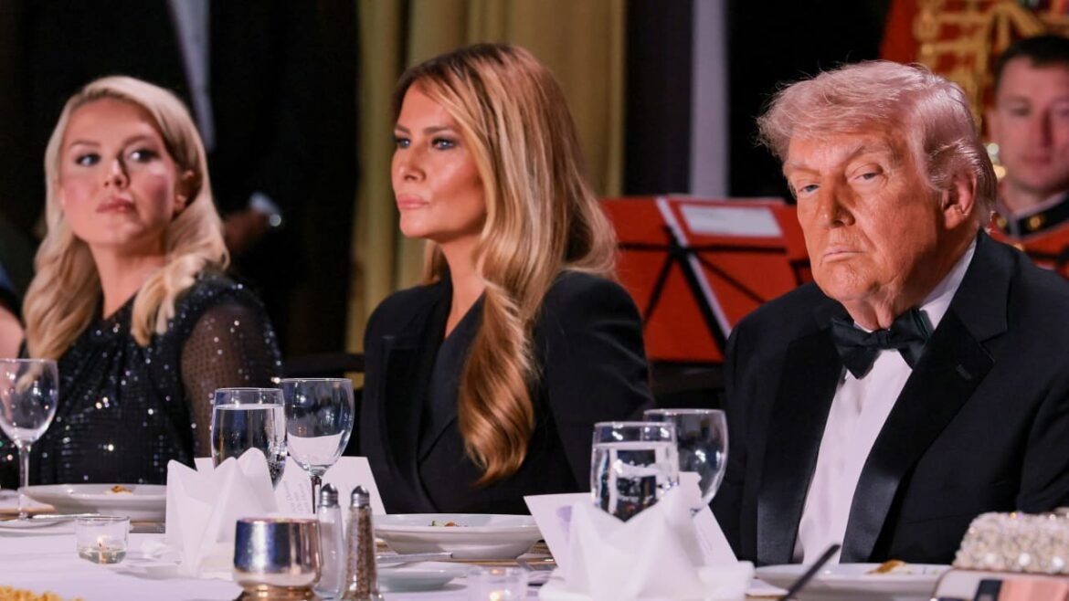Three guests in formal attire sit at a banquet table with folded napkins and glasses of water.