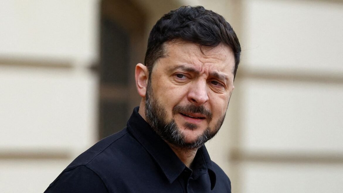Man with dark hair and a trimmed beard wearing a black shirt, looking off to the side with a worried expression outdoors.
