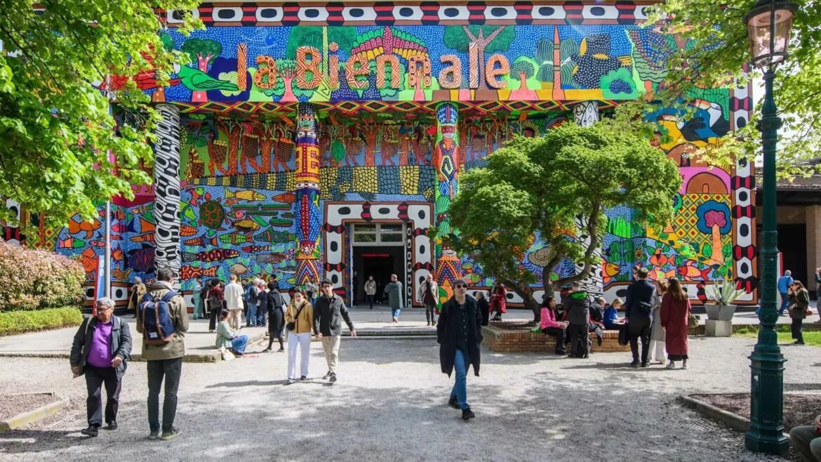 Colorful mural-covered building entrance with people walking in a sunny courtyard.