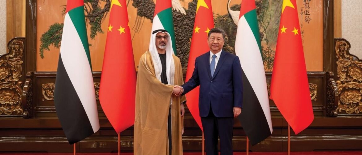 UAE official and a Chinese official shake hands in a formal room, with UAE and China flags behind them.