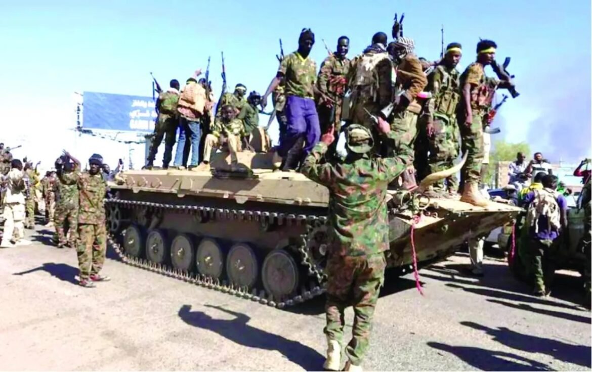 Group of uniformed soldiers and fighters standing on a large armored tank on a street, with people and vehicles nearby on a sunny day
