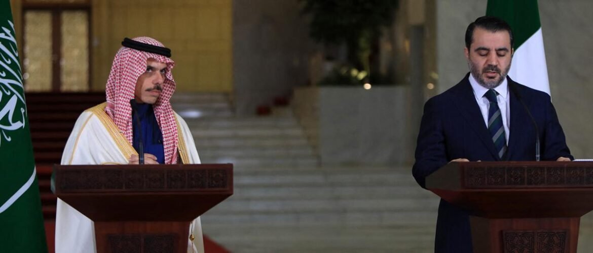 Two men stand at podiums delivering speeches at a formal event, with flags in the background.