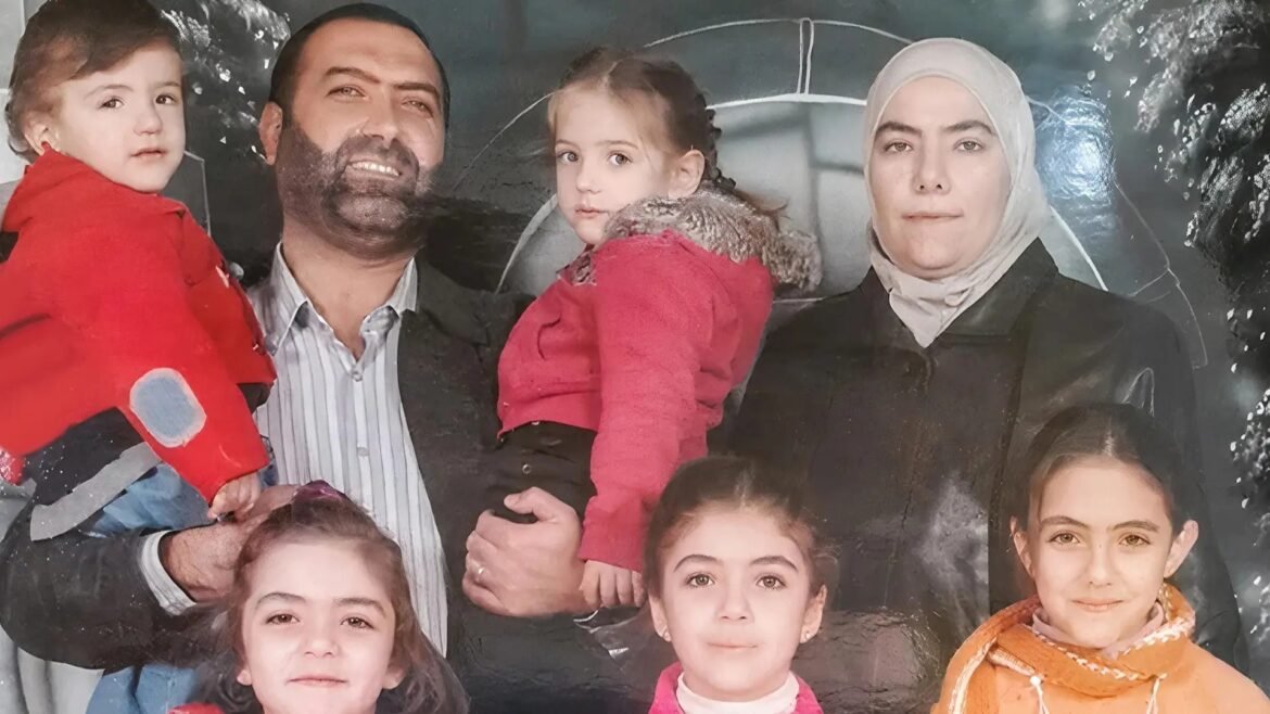 Family portrait of parents with several children smiling at the camera.