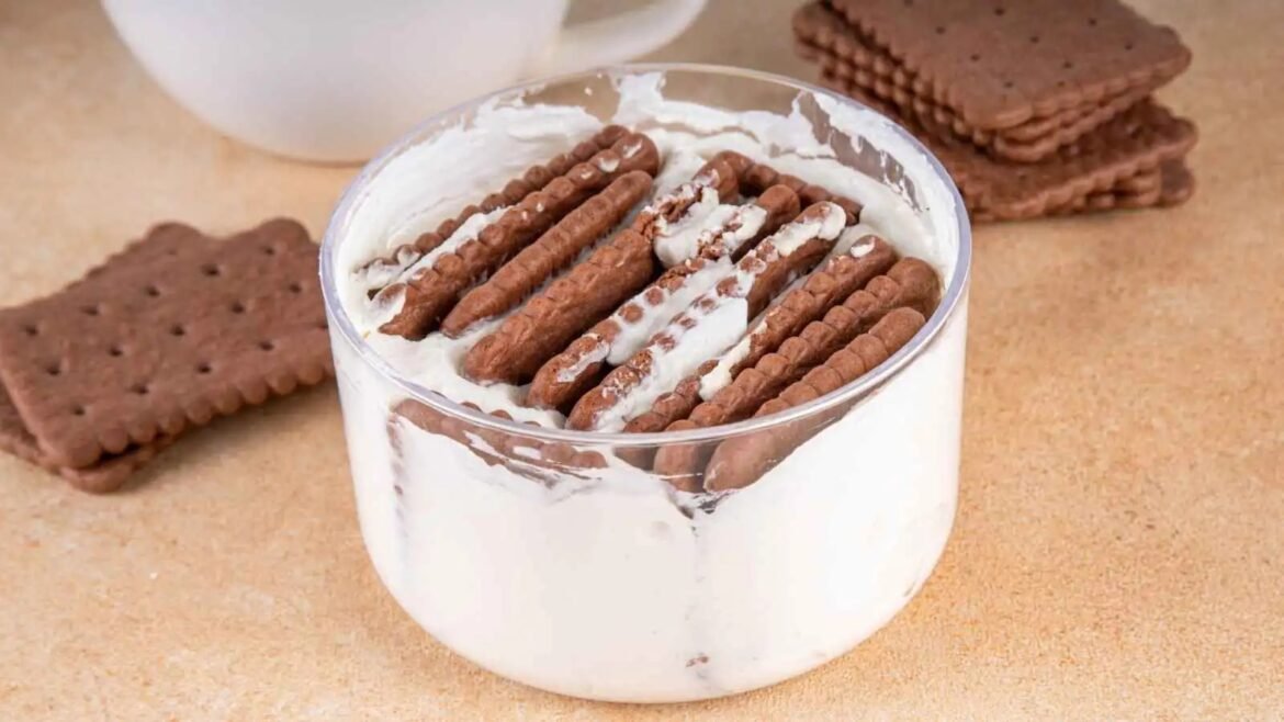 Glass jar filled with whipped cream and chocolate wafer cookies arranged on top, a dessert treat ready to serve