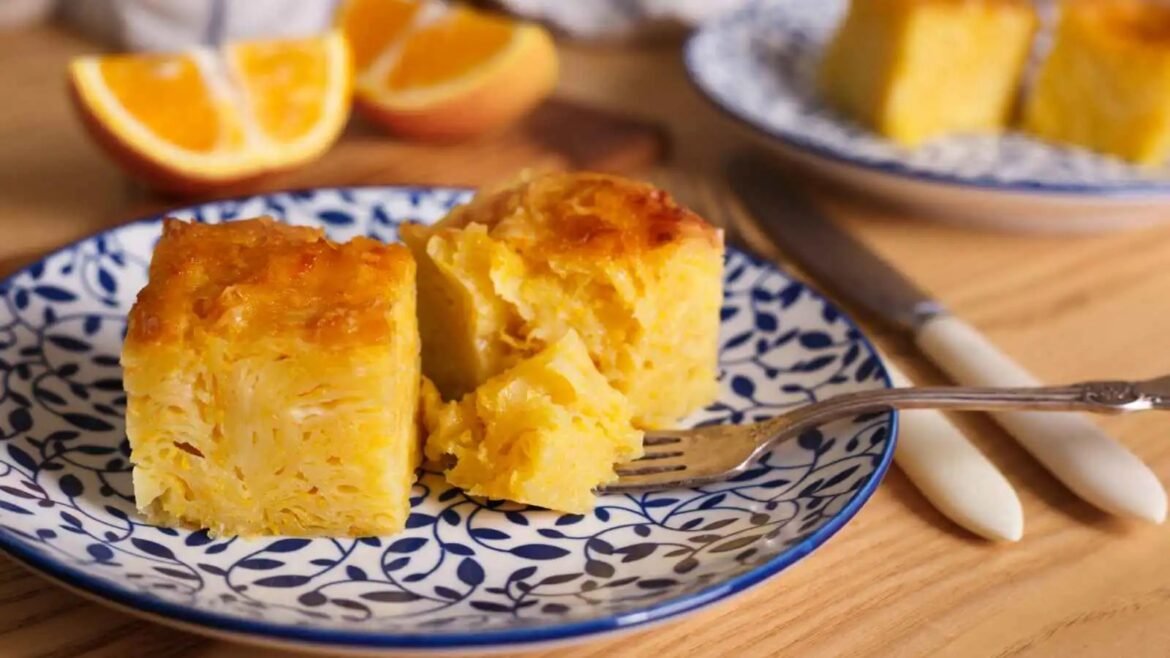 Two pieces of golden orange-flavored cake on a blue patterned plate, with a fork nearby.