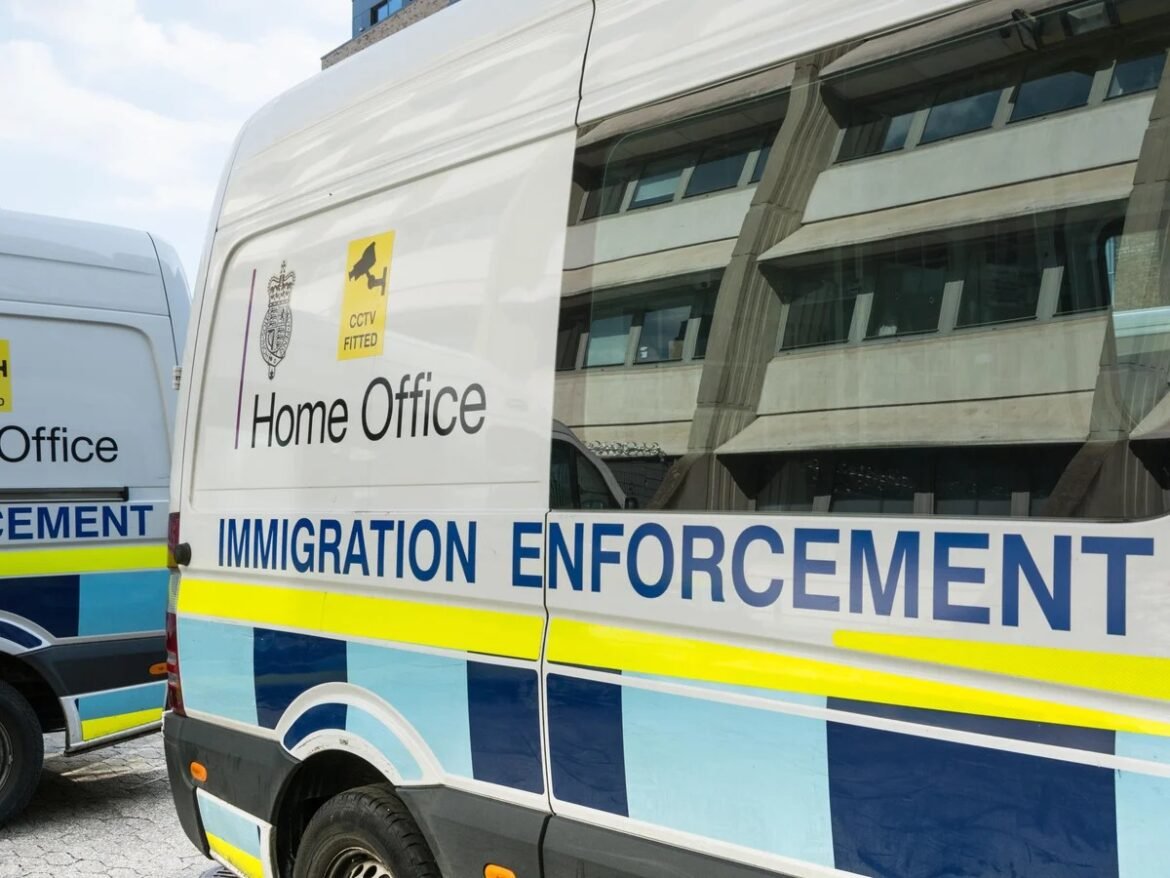 Immigration Enforcement van with Home Office branding and CCTV sticker in a city street scene