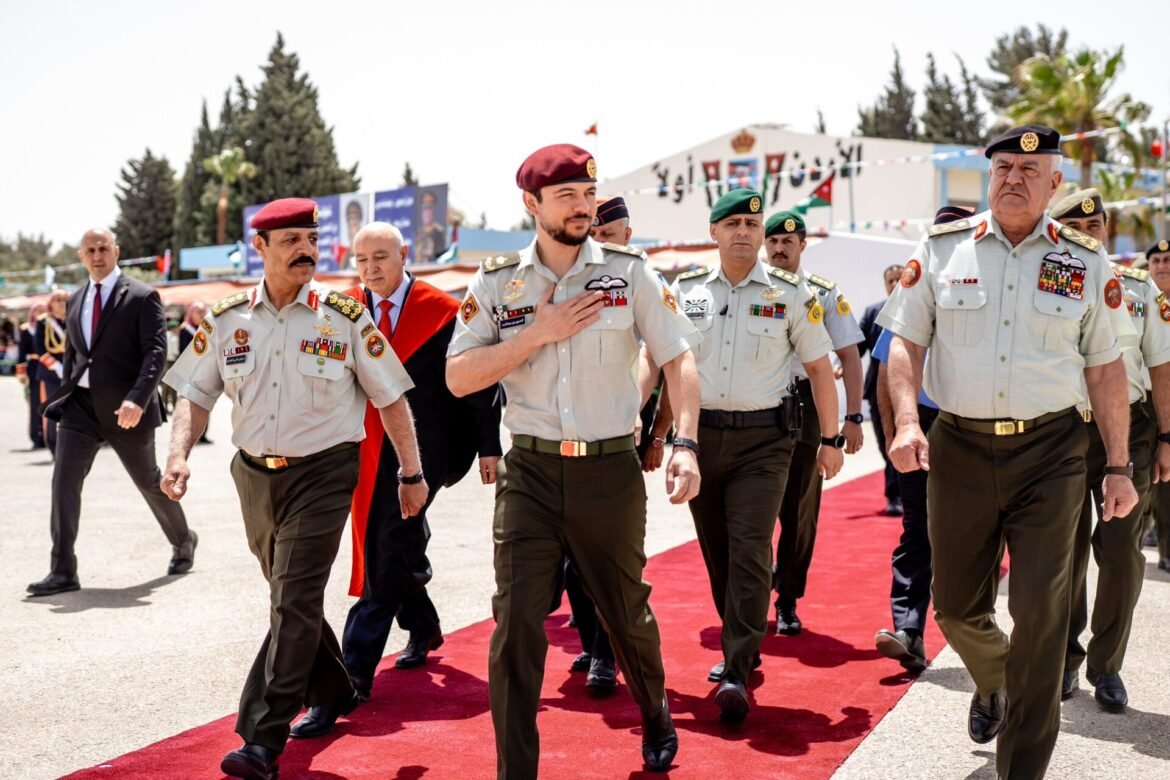 Group of uniformed soldiers marching on a red carpet at an outdoor ceremony, medals on their chests