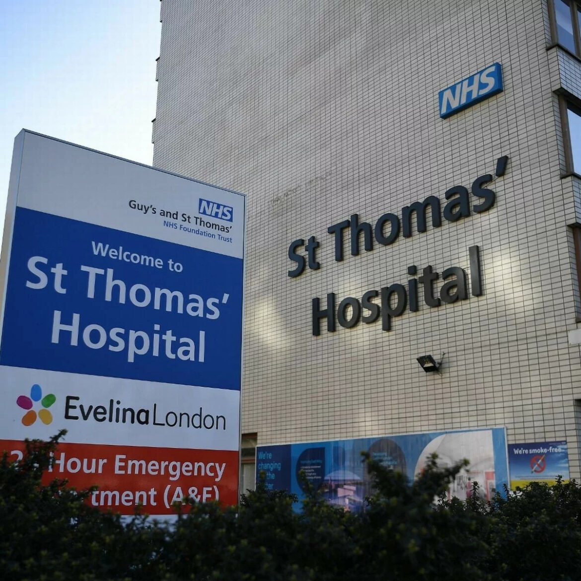 St Thomas' Hospital building with large signage and an NHS sign visible outside the entrance area.