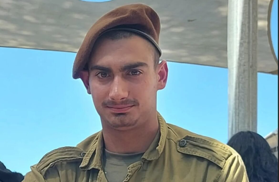 Young man wearing a brown beret and khaki jacket, looking at the camera outdoors.