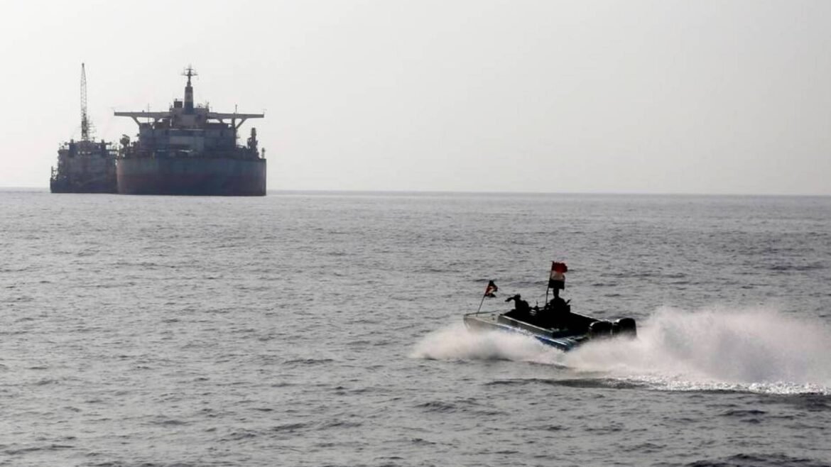 Large bulk carrier on the horizon as a small speedboat races by in the foreground through open water, with flags on the boat.