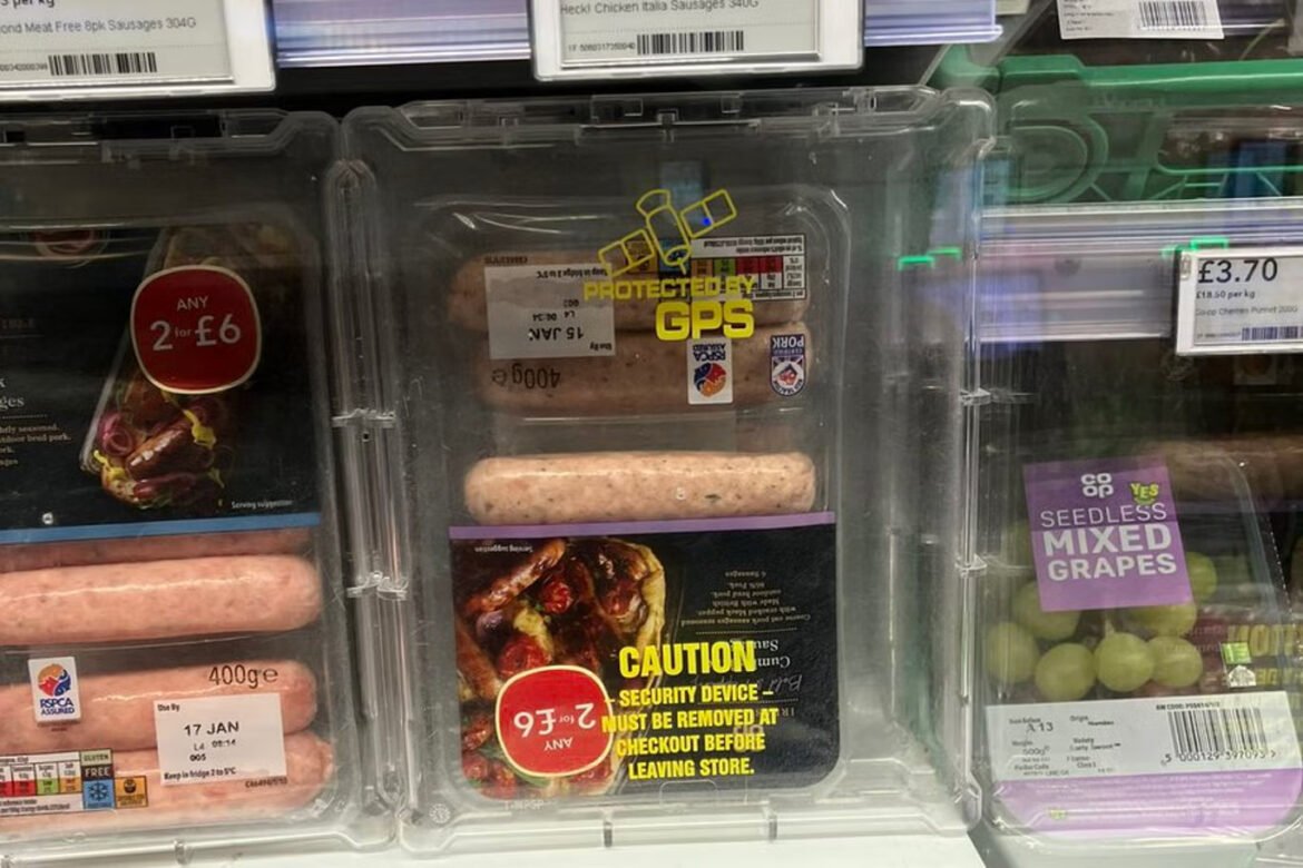 Clear refrigerated meat case displaying raw sausages in plastic packaging with price labels and a yellow 'CAUTION' sticker on one package.