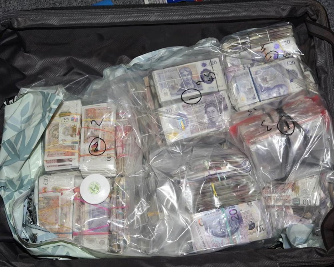 Open suitcase stuffed with bundles of euro banknotes sealed in clear plastic bags, labeled with numbers/marks for counting.