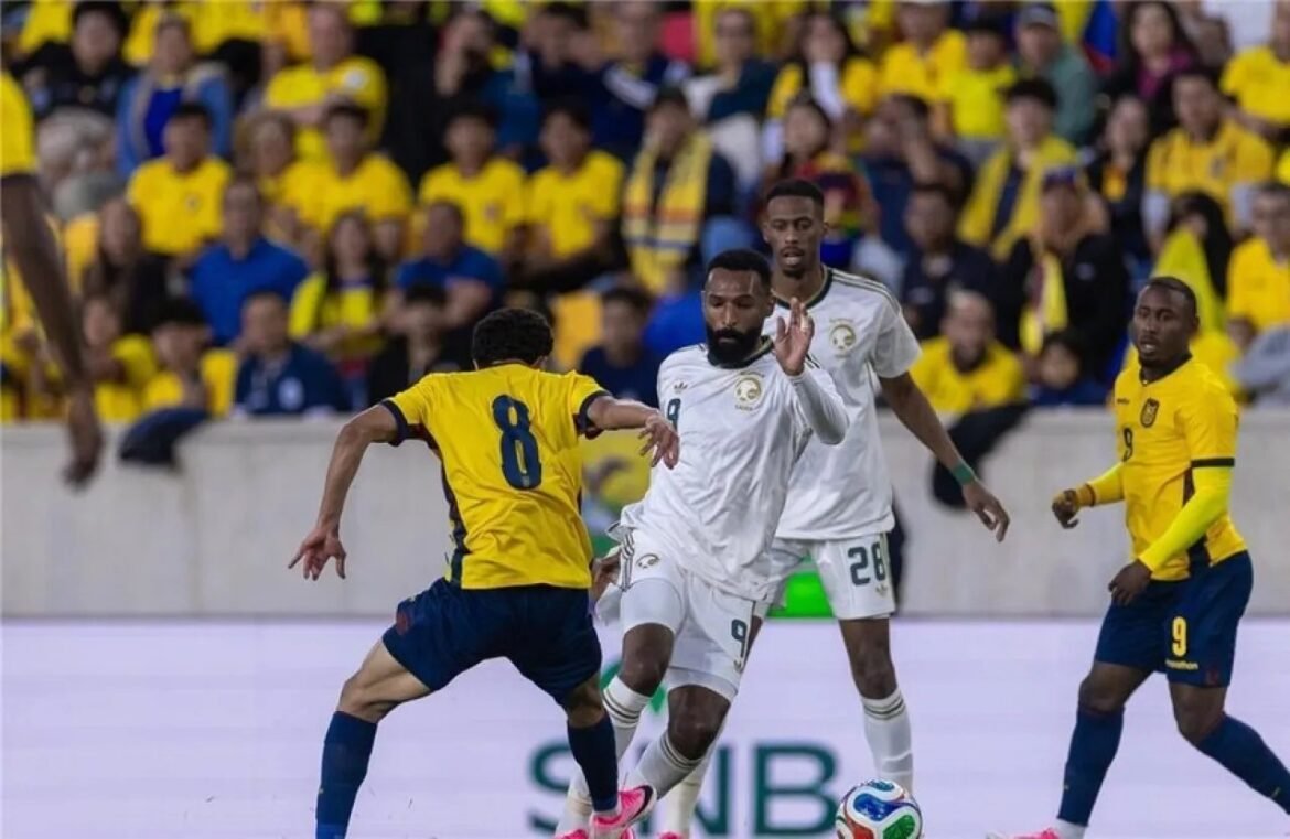 Soccer match moment: a yellow-jersey striker challenges a white-jersey defender for the ball as a crowded stadium looks on.