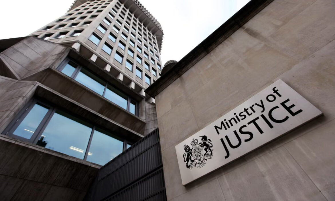 Exterior view of a modern government building with a 'Ministry of Justice' sign on a stone wall, low-angle perspective