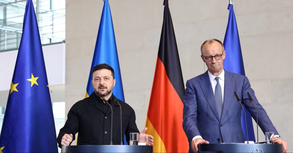 Two men speak at a press conference behind podiums, with EU, Ukraine, and Germany flags in the background.