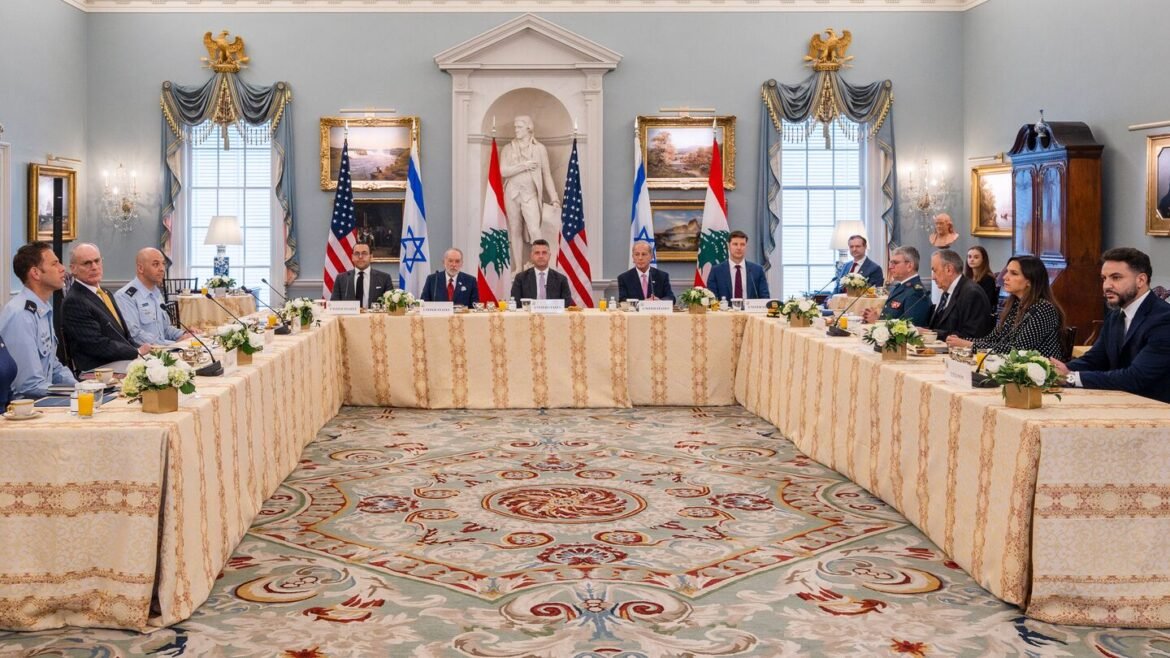 Diplomatic roundtable in a grand room with flags (US, Israel, Lebanon) behind seated officials and floral centerpieces on a beige tablecloth-lo.
