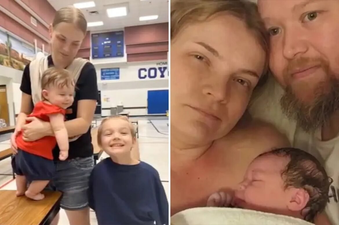 A mother in a gym holds a small baby while a smiling older child stands beside her.