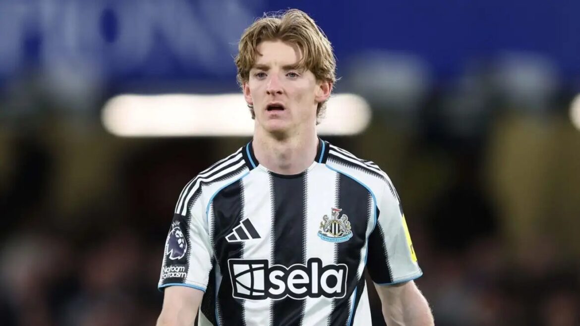 Male soccer player in a black-and-white striped Newcastle United jersey on the field, looking focused during a match.