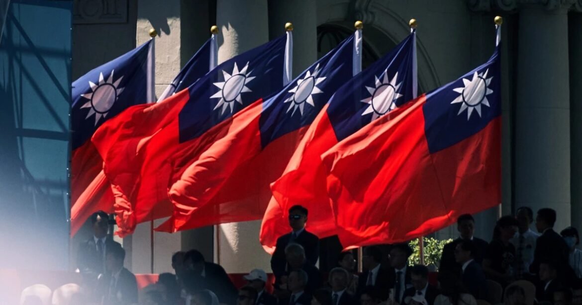 Row of blue-and-red Taiwan flags (Republic of China) fluttering at a formal outdoor ceremony with attendees in the background