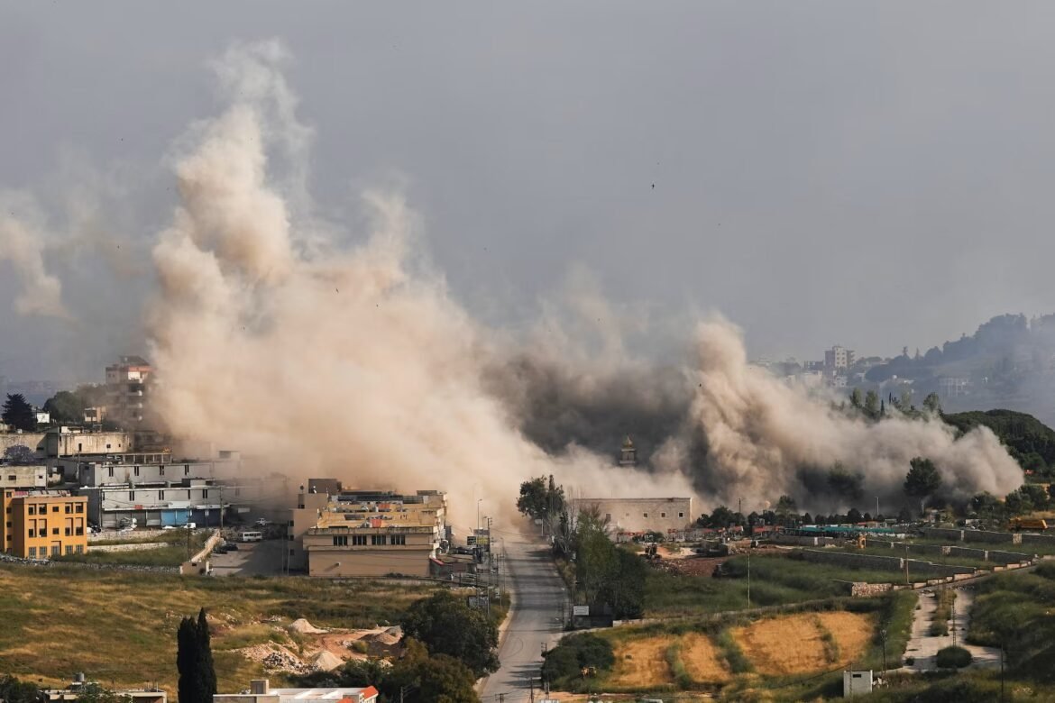 Large brown and gray smoke plume rising from a city street, dust clouds obscuring buildings and cars as an explosion ripples through a residential area.