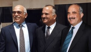 Three Men in Business Suits Smiling Together at a Formal Event Posing for a Photo  Aleumumnews