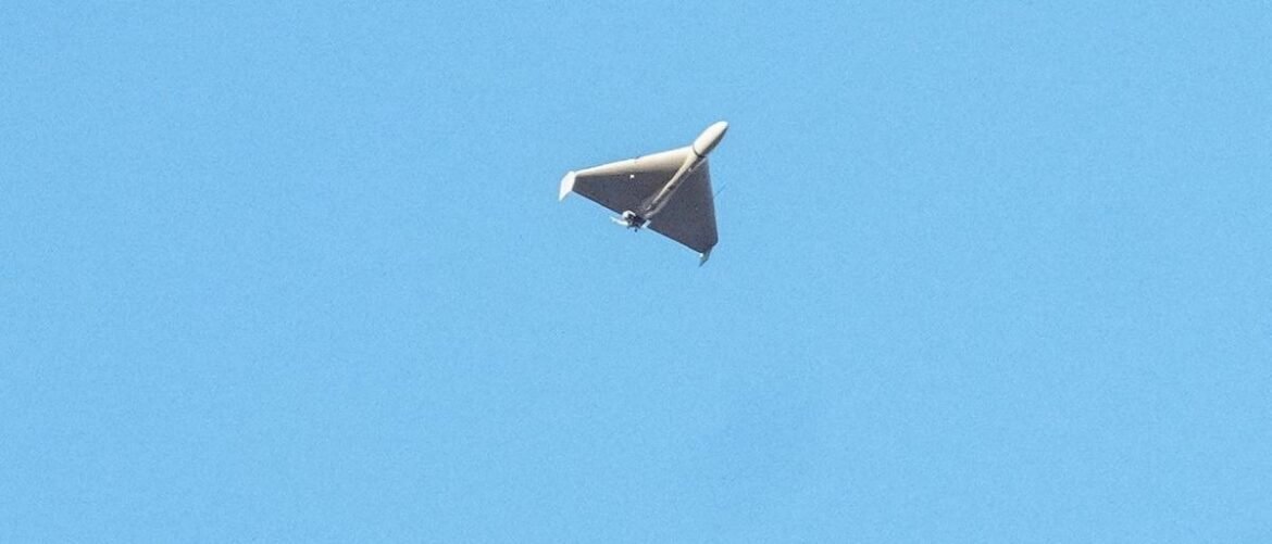 Unmanned aerial vehicle (drone) with a delta wing flying in a clear blue sky