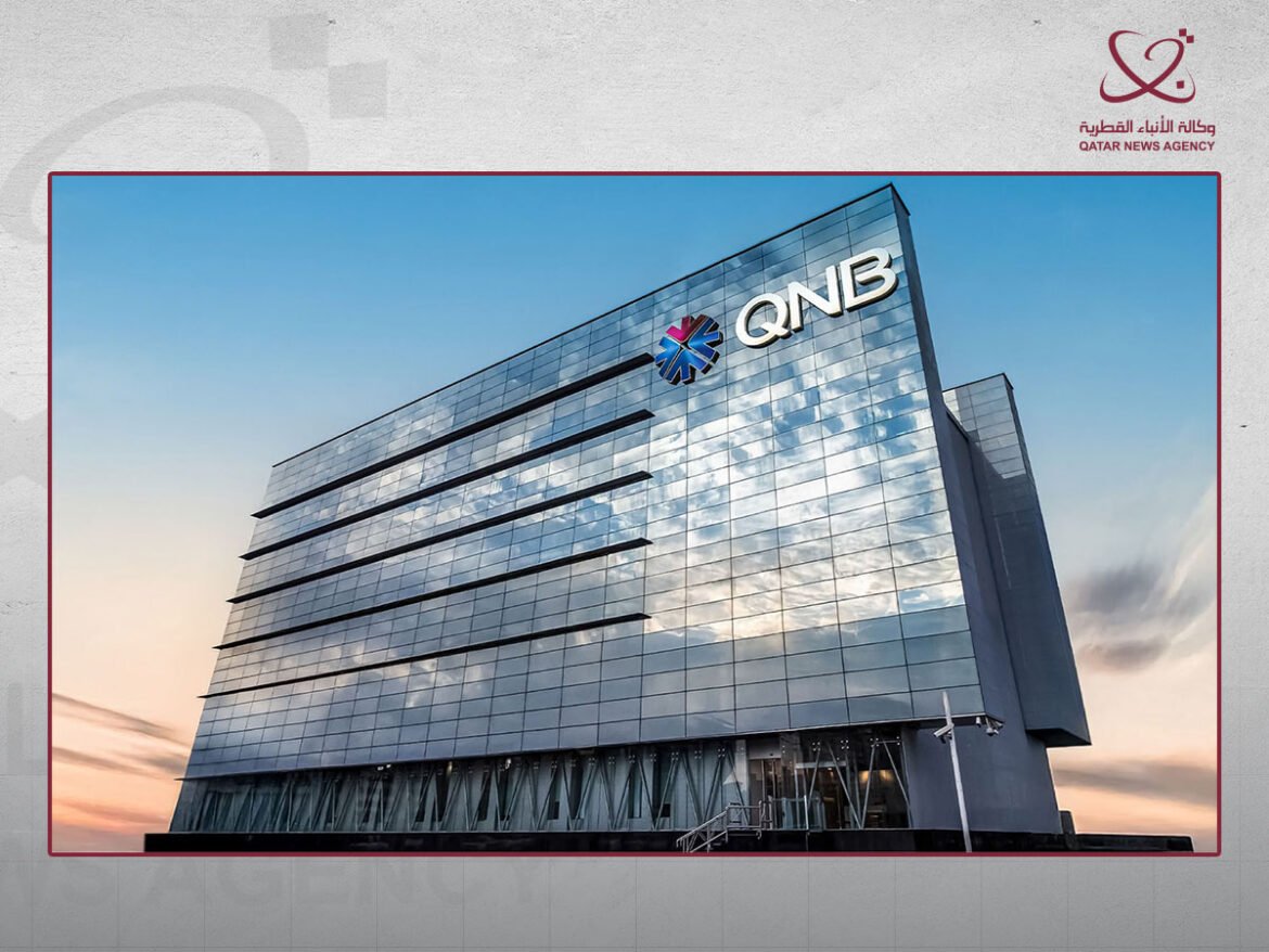 Modern glass-clad building with the QNB logo on the façade, reflecting sunset sky