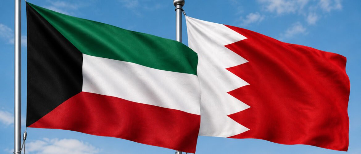 The flags of Kuwait (left) and Bahrain (right) waving in the wind against a blue sky.