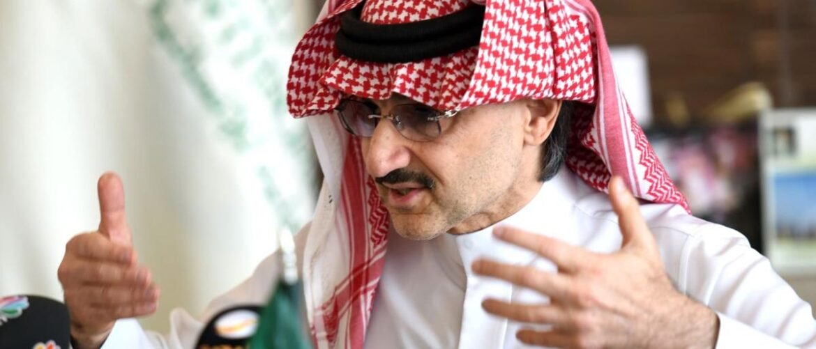 Man wearing a red-and-white keffiyeh and white thobe speaking with animated hand gestures in a discussion .