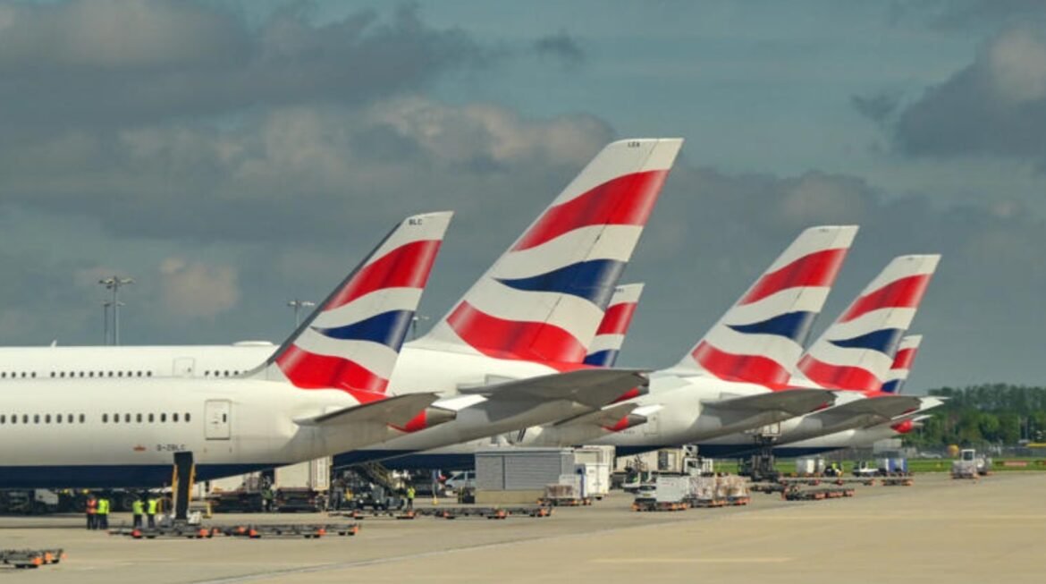 Row of British Airways aircrafts parked at the gate with distinctive red, white and blue tail fins lining up at the apron.