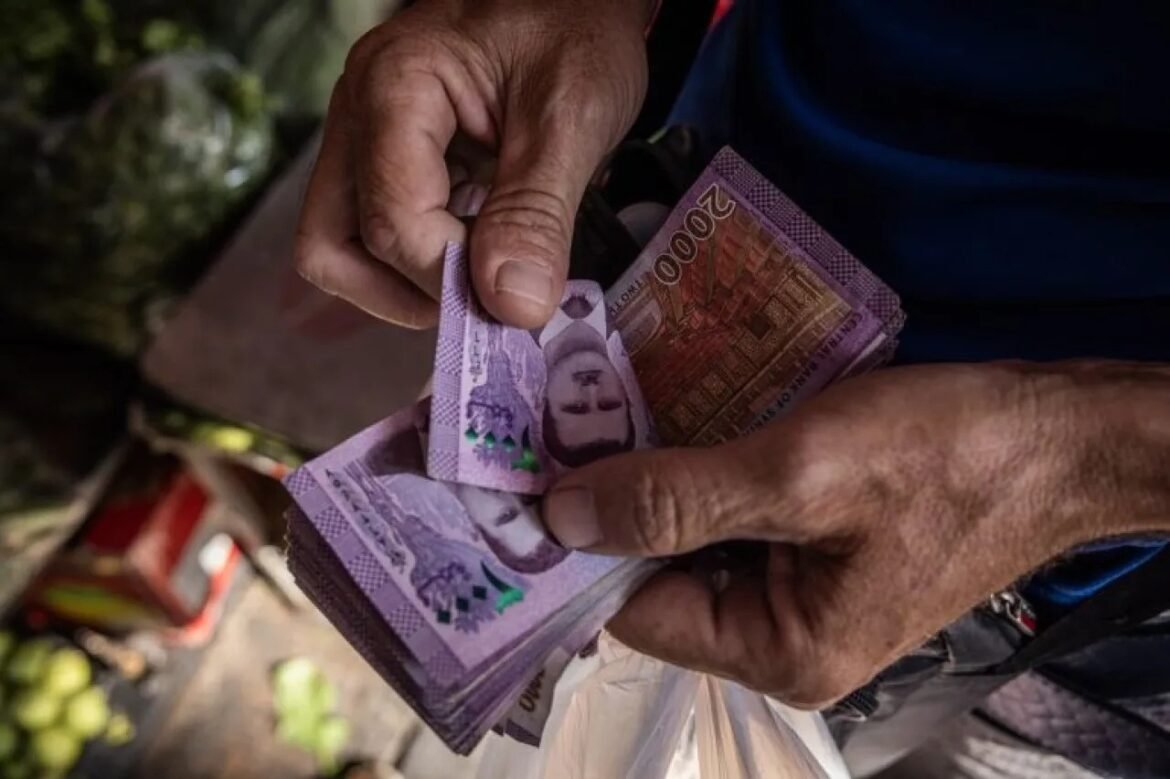 Close-up of weathered hands counting purple 20,000-rupiah banknotes.