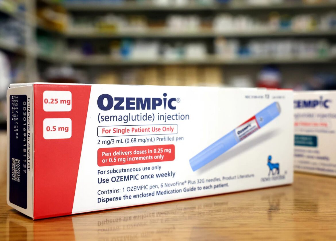 Box of Ozempic semaglutide injection on a wooden table in a pharmacy, showing 0.25 mg and 0.5 mg dosing labels and 'For Single Patient Use Only' text