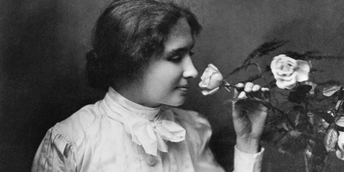 Young girl in a vintage white blouse smelling a bouquet of roses (black-and-white portrait)
