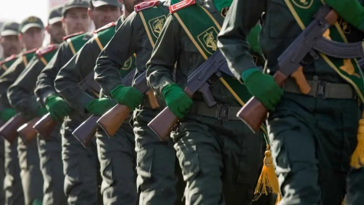Line of soldiers in green uniforms marching in formation with rifles.