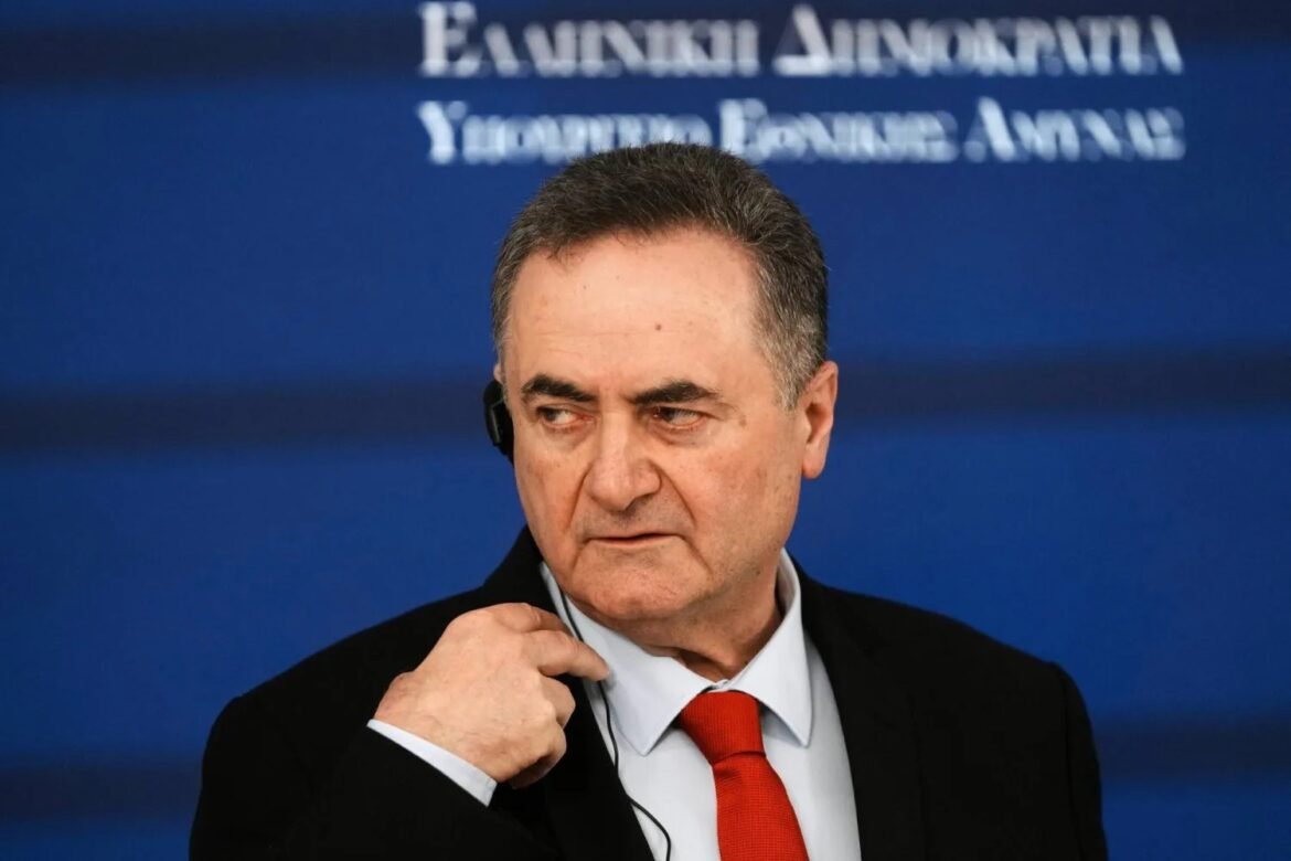 Middle-aged man in a dark suit and red tie wearing a headset, against a blue backdrop.