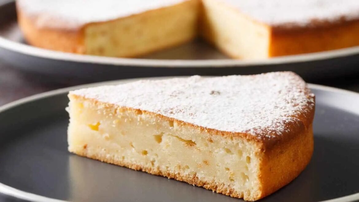 Slice of cheesecake on a dark plate, lightly dusted with powdered sugar.