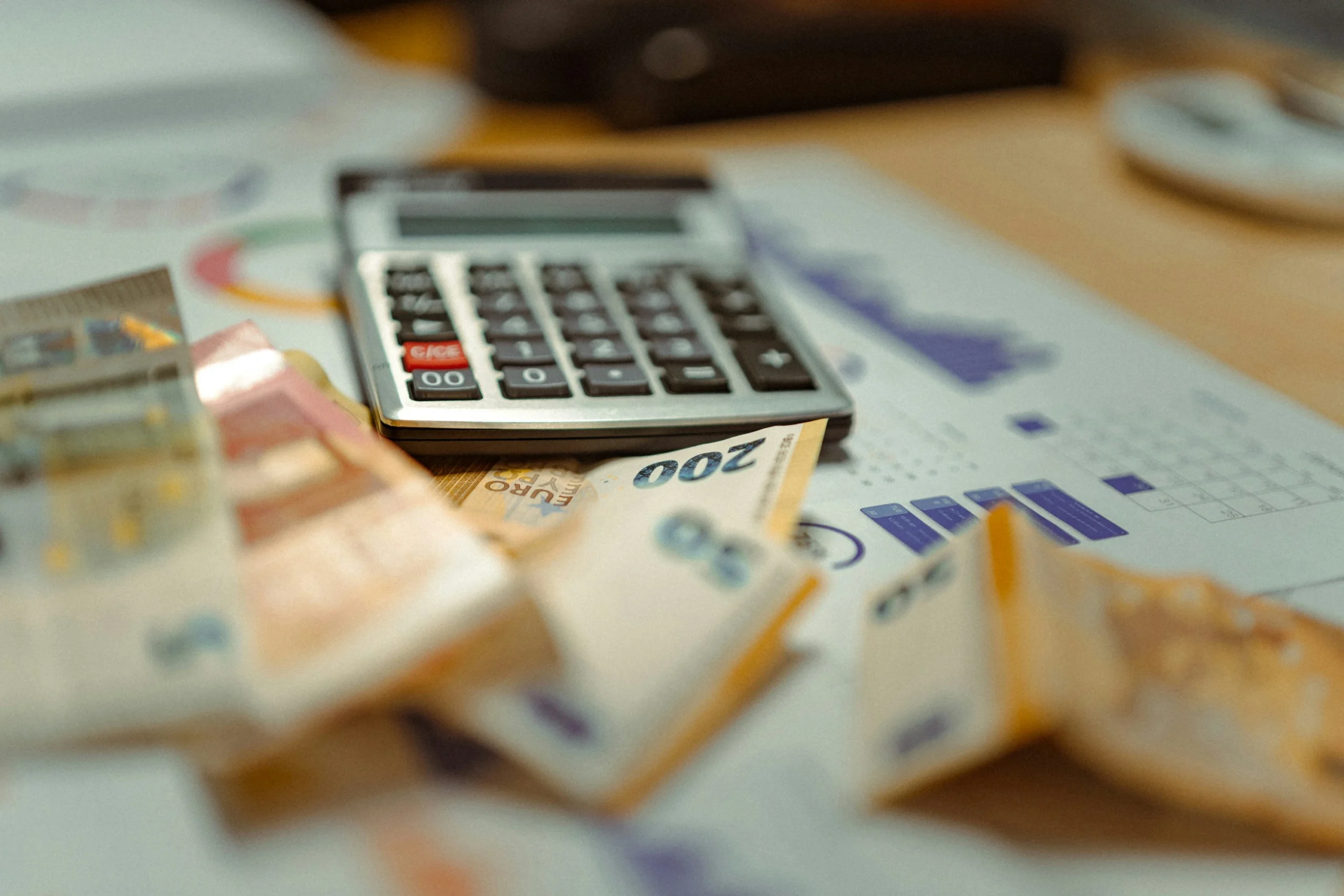 Calculator on a Desk Surrounded by Euro Banknotes and Documents Suggesting Budgeting or Accounting  Aleumumnews