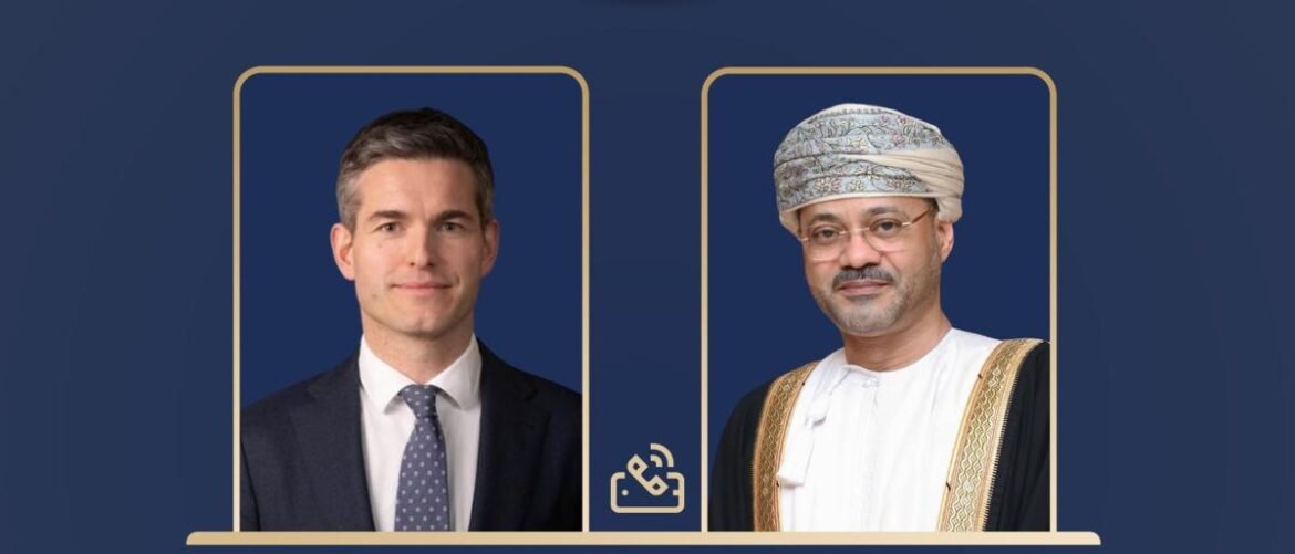 Two framed portrait photos on a blue background: a businessman in a suit on the left and a man in traditional Omani attire on the right.