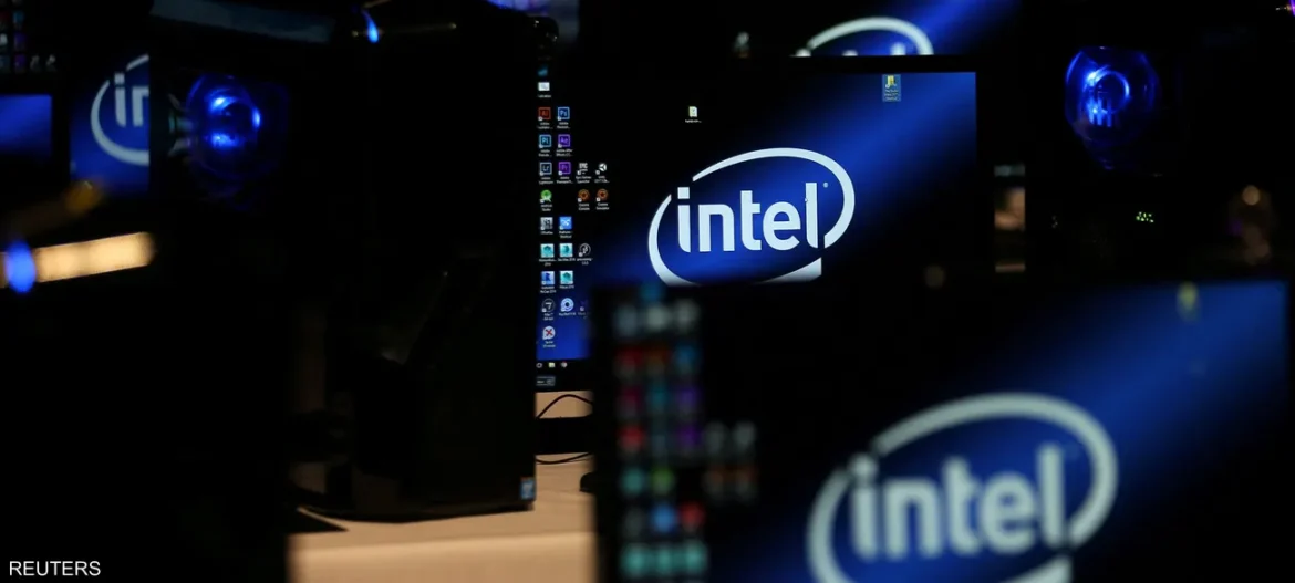 Several computer monitors displaying an Intel logo in a dark, tech exhibition setting.