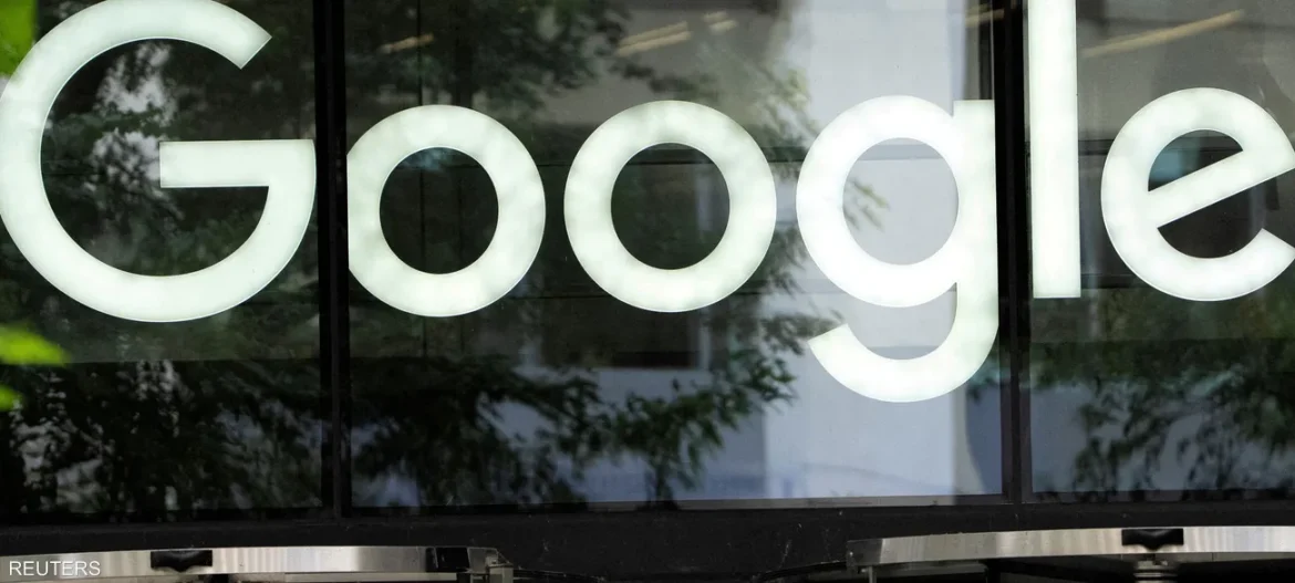 Close-up of a Google logo on a glass storefront, with tree reflections in the window glass.