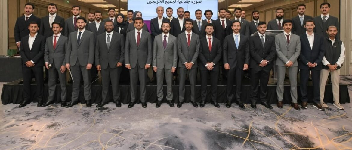 Group photo of dozens of professionals in suits standing on a stage at a conference or event.