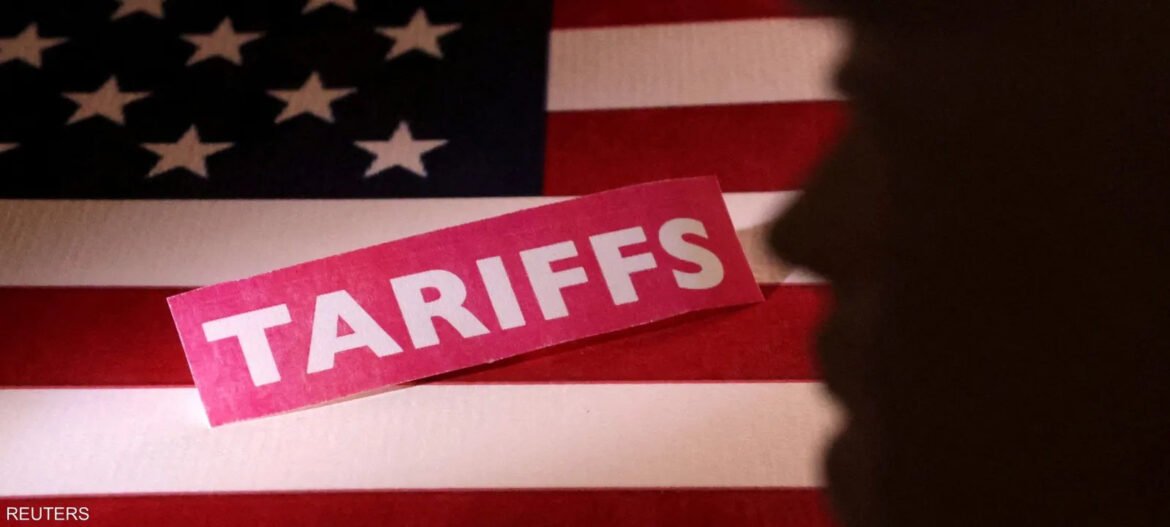 Pink adhesive label reading 'TARIFFS' laid over a waving U.S. flag, with a dark silhouette on the right edge (Reuters photo)