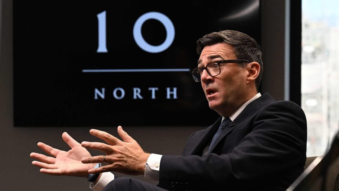 Man in a suit and glasses speaks passionately, hands spread as he talks, with a '10 NORTH' logo on a screen behind him.