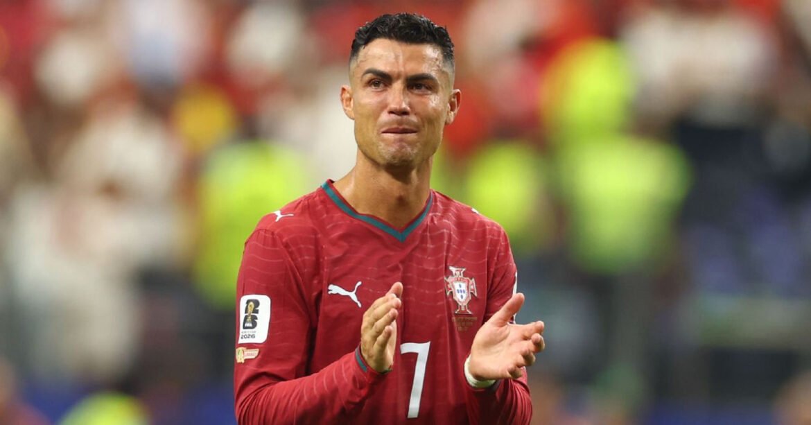 Soccer player in a red Portugal jersey with number 7 clapping on the field.