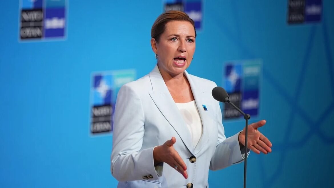 Woman in a light blue blazer speaks at a microphone on a blue stage, gesturing with her hands during a press conferencecrisis or political event (informative)
